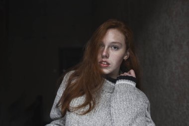 Karanlık odada çilleri olan çekici genç bir manken.