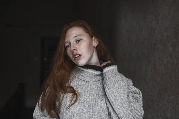 Tender young model with freckles posing in the dark room — Stock Photo, Image