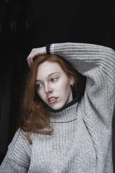 Karanlıkta çilleri olan çekici genç bir kadın.