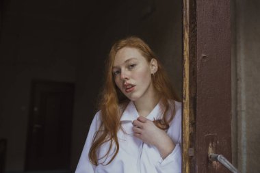 Ahşap kapının yanında çilli kızıl saçlıya modeli