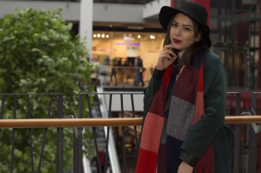 Alışveriş merkezinde yeşil paltolu şık modeli