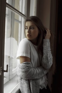 Uzun saçlı penceresine bakarak şehvetli genç modeli