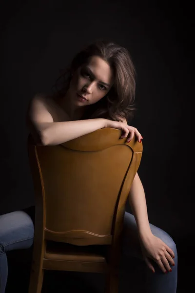 Gyönyörű meztelen nő egy székre, a sötét szobában — Stock Fotó