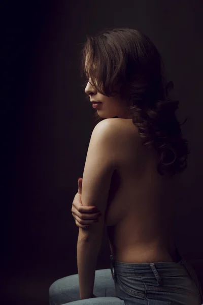 Mujer desnuda con exuberante cabello castaño en las sombras — Foto de Stock