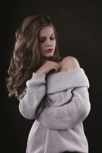 Aantrekkelijke jonge vrouw met naakte schouders in het donker — Stockfoto
