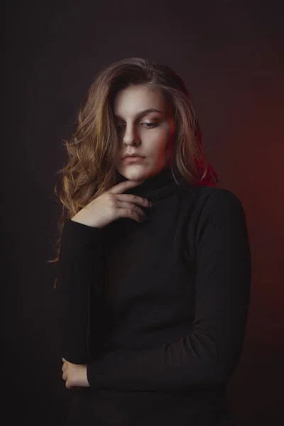 Schöne junge Frau mit üppigen Haaren posiert im Pullover — Stockfoto