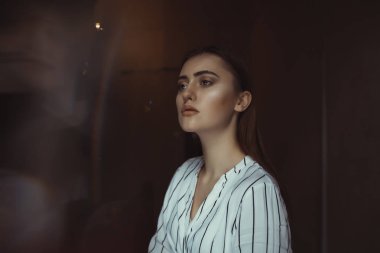 Moda esmer model karanlık odada poz 