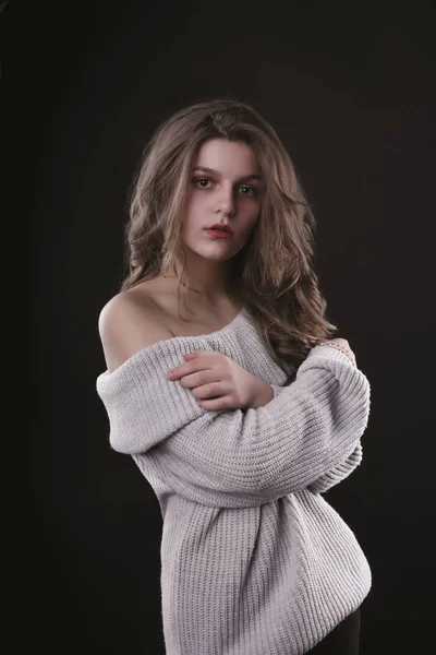 Wanita muda yang indah mengenakan sweater dengan bahu telanjang — Stok Foto