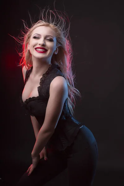 Усміхнена блондинка в корсеті і червоне світло в студії — стокове фото