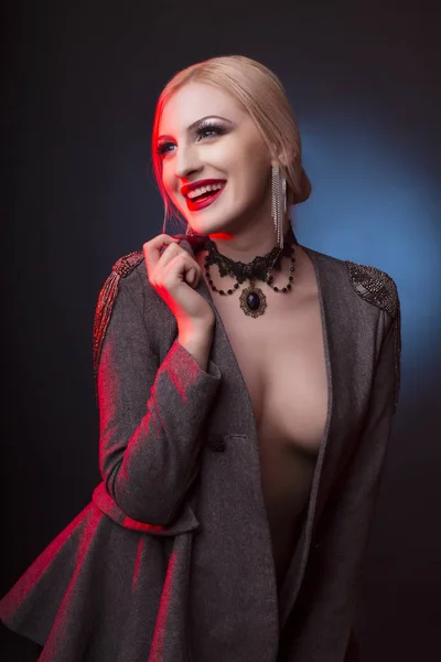 Uśmiechający się kobieta z jasny makijaż i ubrany w płaszcz — Zdjęcie stockowe