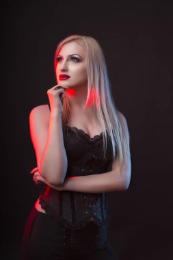 Bir korse kırmızı ve mavi ışık ile baştan çıkarıcı sarışın Bayan