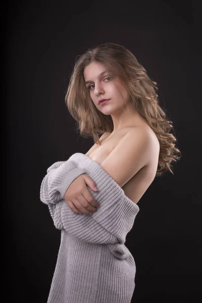 Mujer joven romántica posando en suéter con hombros desnudos — Foto de Stock