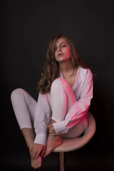 Mooie jonge vrouw in hemd met rode studio light — Stockfoto