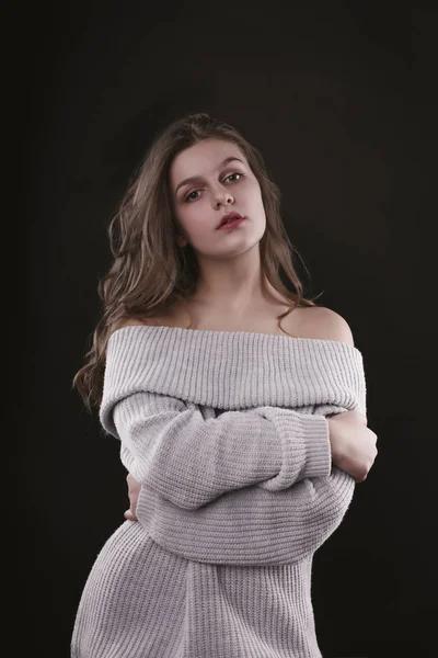Красивая молодая модель в трикотажном свитере с голыми плечами — стоковое фото