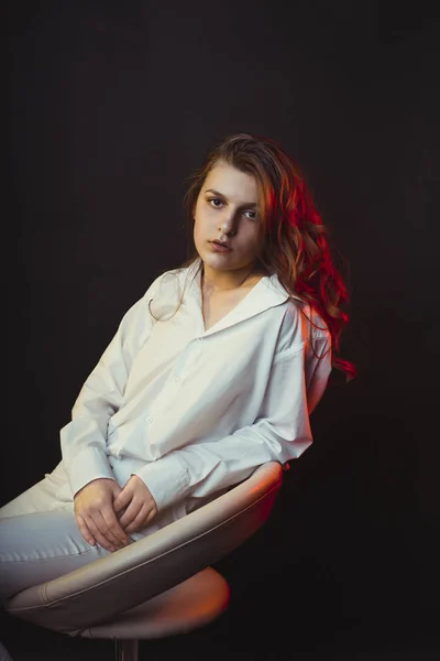 Lovely young woman in shirt with red studio light — Stock Photo, Image