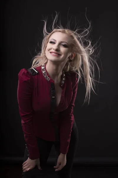 Glückliches junges Model mit Haaren am Wind im Studio — Stockfoto