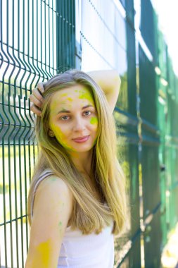 Yeşil ve sarı toz Holi yüzünde güzel bayanı