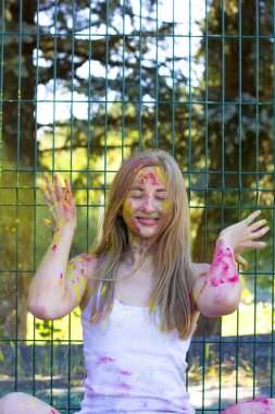 Sarı tozu Holi parkta yukarı atma mutlu sarışın kadın