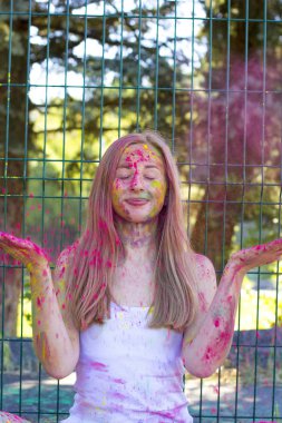 Çekici sarışın kadın atmak kuru boya Holi Park