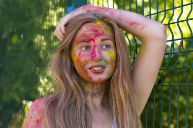 Gülümseyen yüzünde Holi renkli toz ile sarışın kadın