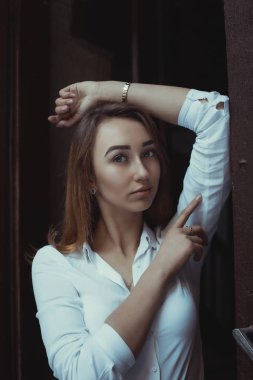 Beyaz gömlek giymiş ve karanlıkta poz güzel genç model