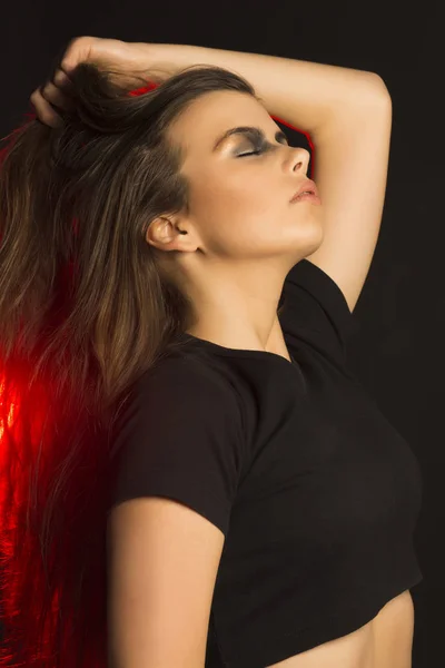 Doskonały brunetka kobieta sztuka makijażu w studiu z czerwonym świetle — Zdjęcie stockowe