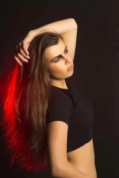 Mujer morena de moda con maquillaje de arte en el estudio con li rojo —  Fotos de Stock