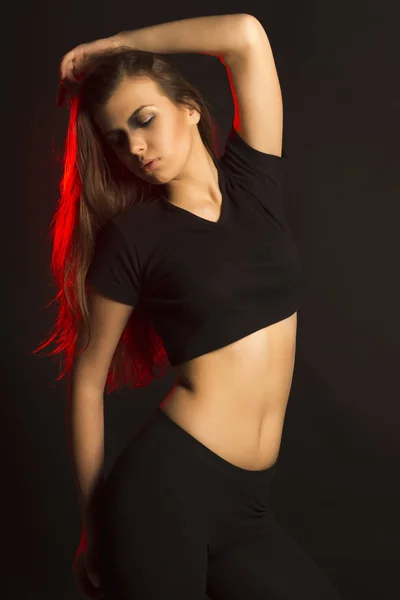Junge stylische Frau posiert im Studio mit Rotlicht — Stockfoto