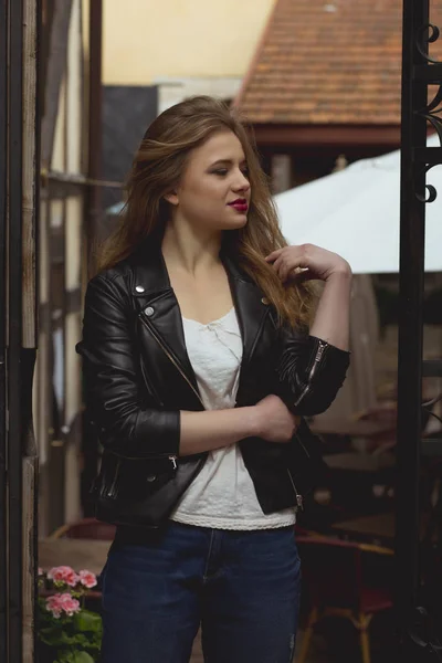 Unga trendiga kvinna klädd i snygg jacka och jeans på t — Stockfoto