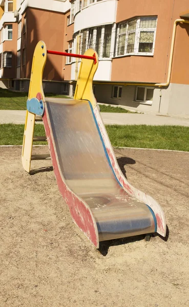 Corrediça de crianças em um playground perto do edifício residencial — Fotografia de Stock