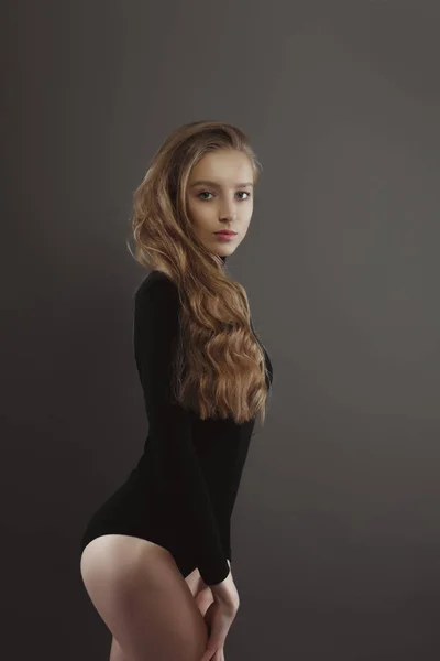 Modelo de teste com jovem modelo bonito com cabelo loiro exuberante em cinza — Fotografia de Stock