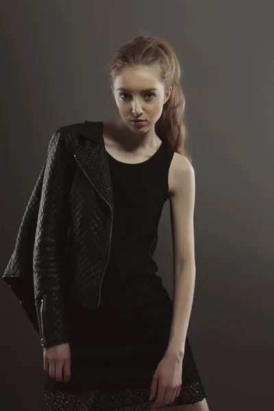 Αρκετά νεαρό μοντέλο ποζάρει για δοκιμές μοντέλου σε μαύρο φόρεμα στο stud — Φωτογραφία Αρχείου