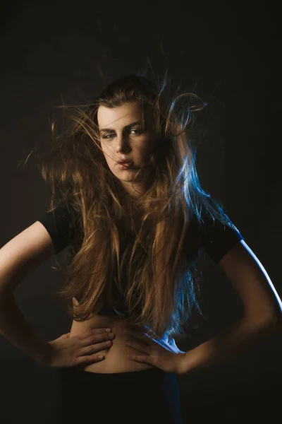 Młoda kobieta z fruwające włosów z wiatrem pozowanie Studio — Zdjęcie stockowe