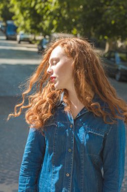 Çekici Kızıl saçlı modeli st, güneş ışınlarının kot gömlek