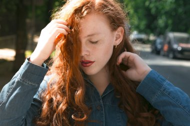 Şehvetli redhead modeli ile güneş ışınlarının kot gömlek kapalı 