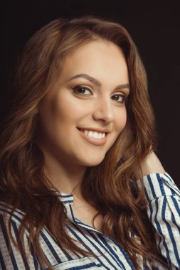 Genç modeli stüdyoda üzerinde siyah bir backg poz gömlek gülümseyen