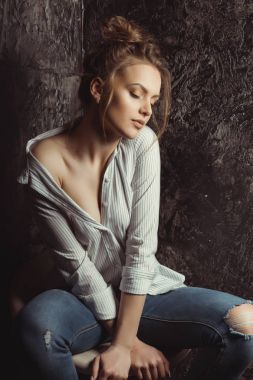 Kapalı gözlerle bir sandalyede oturan seksi genç modeli