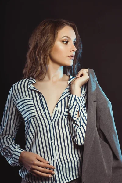 Vacker brunett kvinna poserar i skjorta och hålla hennes jacka — Stockfoto