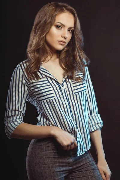 Стильна молода леді позує в смугастій сорочці в студії — стокове фото