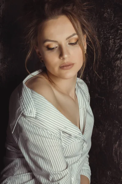 Sensuele brunette model in hemd met naakte schouder over een zwart — Stockfoto