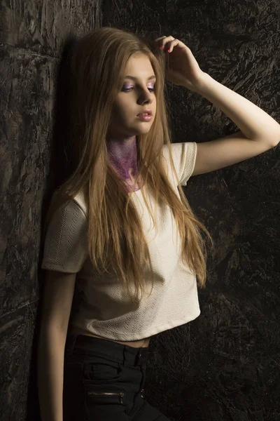 Modne młody model z bujnymi blond włosy pozowanie w ciemnym roo — Zdjęcie stockowe