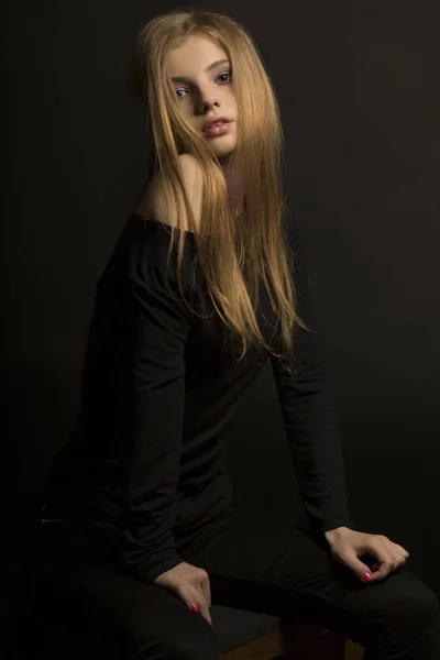 Stylish young woman with glitter on her neck posing at the dark — Stock Photo, Image