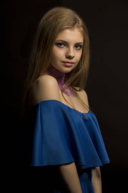 Uzun gür saçlı ve mavi elbise ile çekici sarışın kadın 