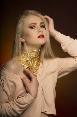 Kırmızı renk ve altın folyo parlak makyaj ile ihale genç modeli