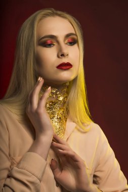 Güzel genç model parlak makyaj ve altın folyo ile. Kırmızı ve y