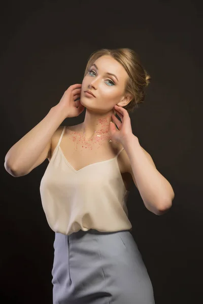 Modella giovane alla moda con brillantini sul collo in studio scuro — Foto Stock