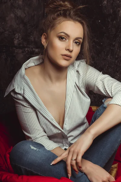 Beautiful woman with natural makeup in shirt and torn jeans — Stock Photo, Image