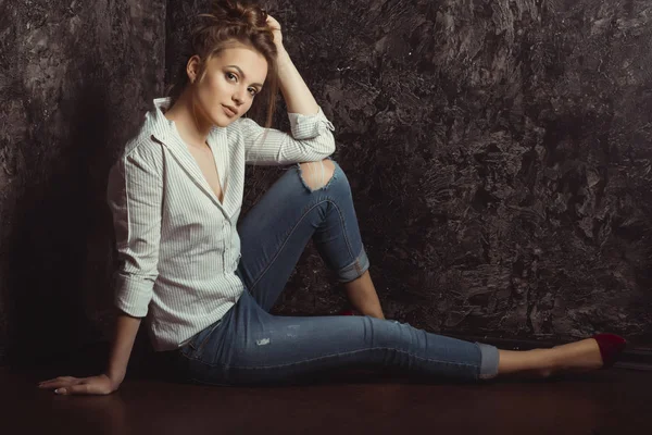 Hübsche brünette Frau mit natürlichem Make-up im Hemd und zerrissener Jeans — Stockfoto