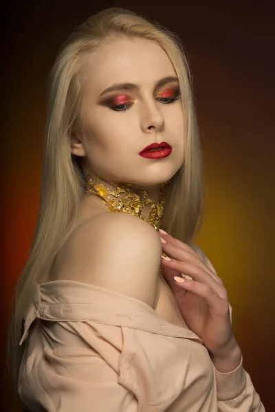 लाल रंग आणि सोन्यामध्ये परिपूर्ण मेकअपसह आकर्षक तरुण स्त्री — स्टॉक फोटो, इमेज