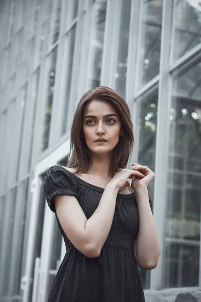 Modelo bonito em um vestido preto na janela — Fotografia de Stock